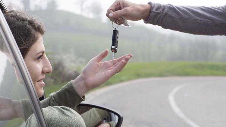 Parental hand dropping car keys into teen driver's hand.